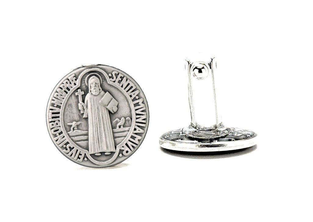 Silver circular medallion with religious design on a white background