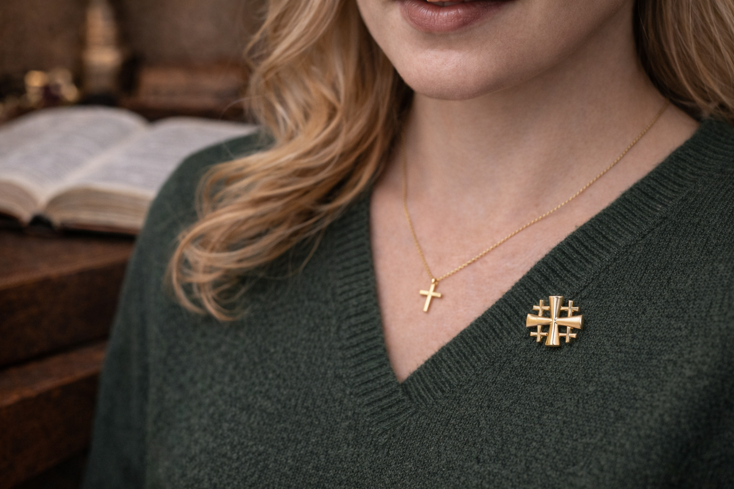 Person wearing a green sweater with gold necklaces featuring a cross and a Jerusalem Cross Lapel Pin – Gold Tone Crusaders Shield Five-Fold Cross