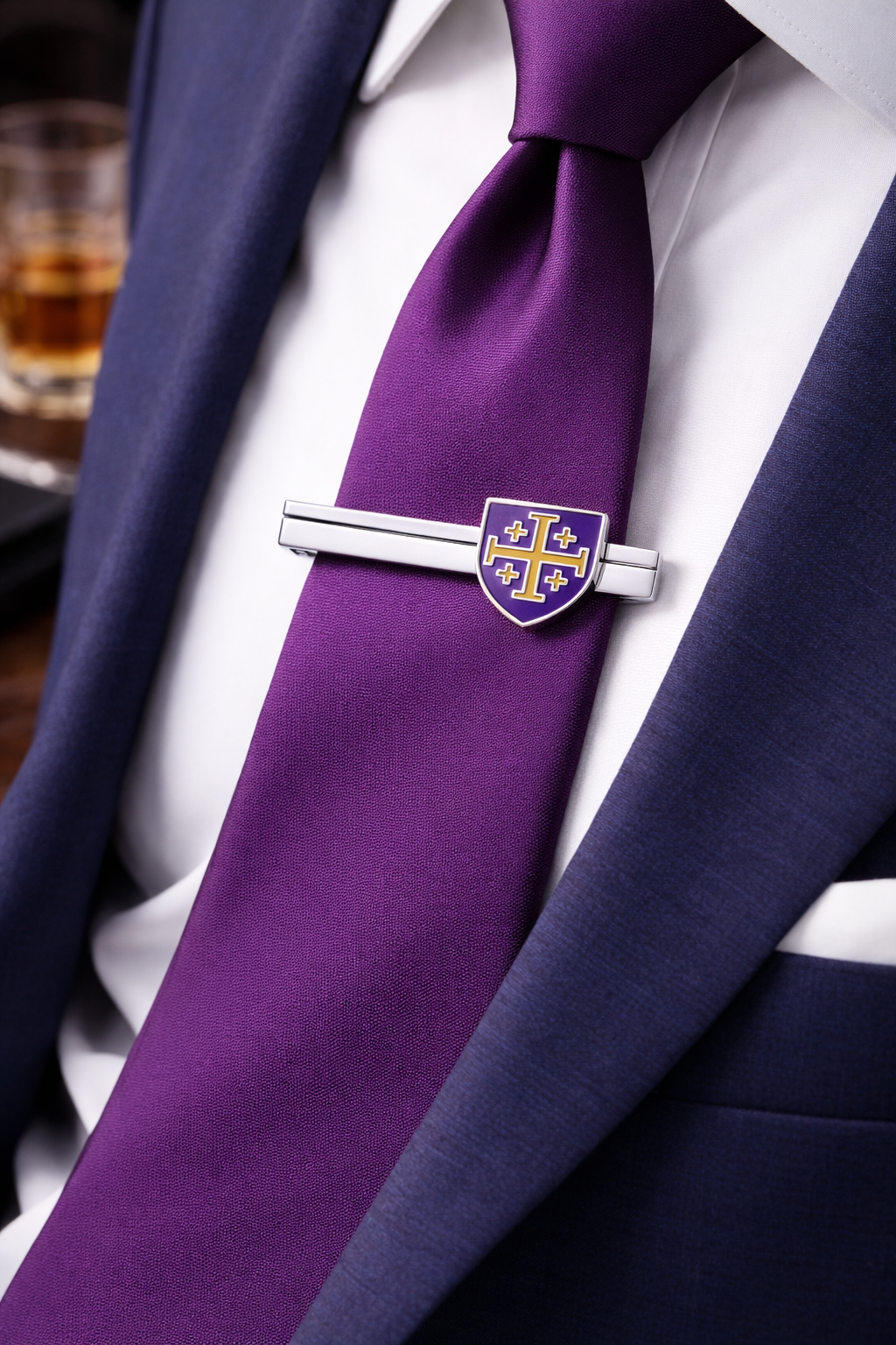 Purple tie with a silver tie clip on a white shirt, close-up view.