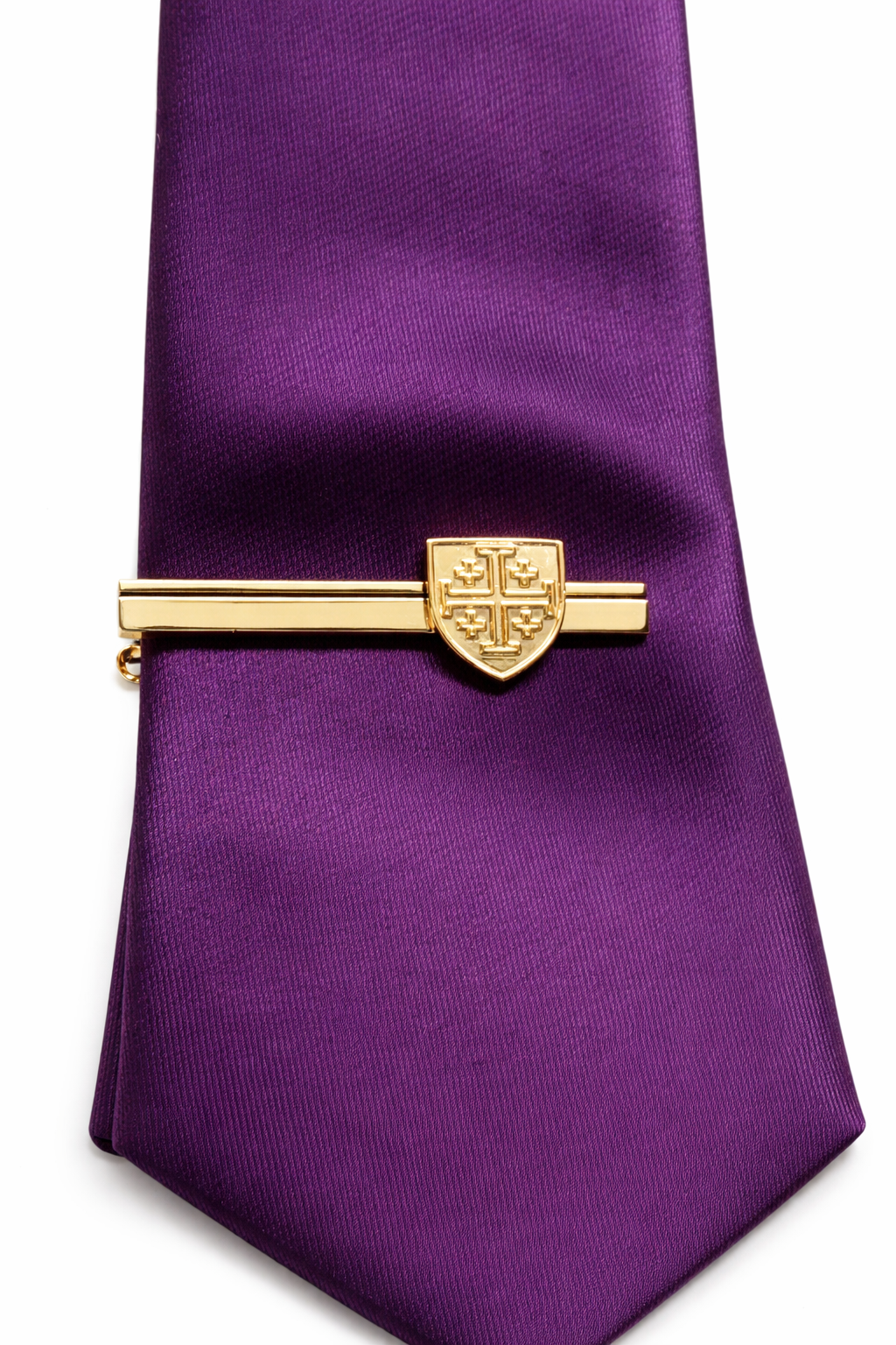 Gold tie clip on a purple tie against a white background