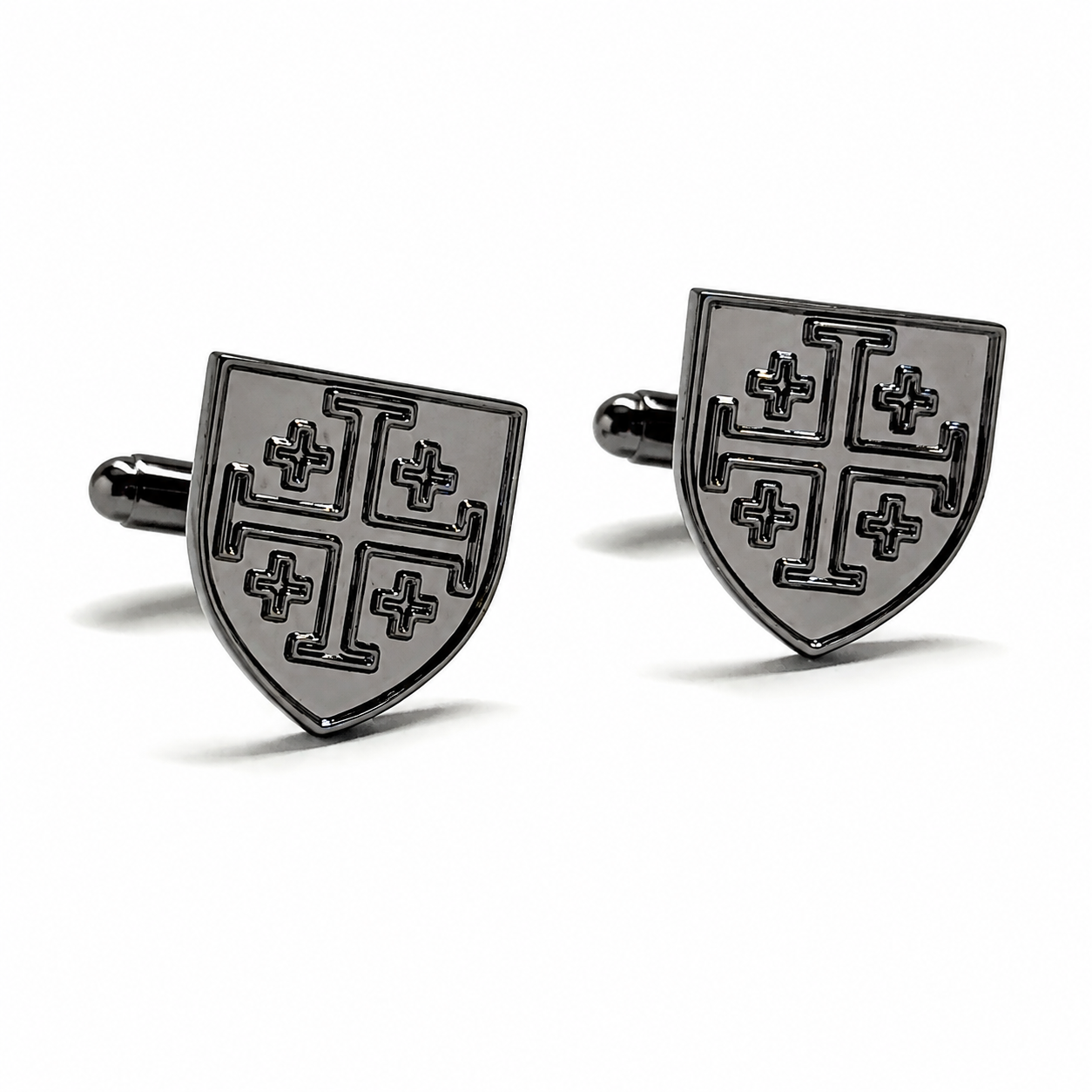 A pair of black metal cufflinks shaped like medieval shields with a cross motif, displayed on a clean white background.