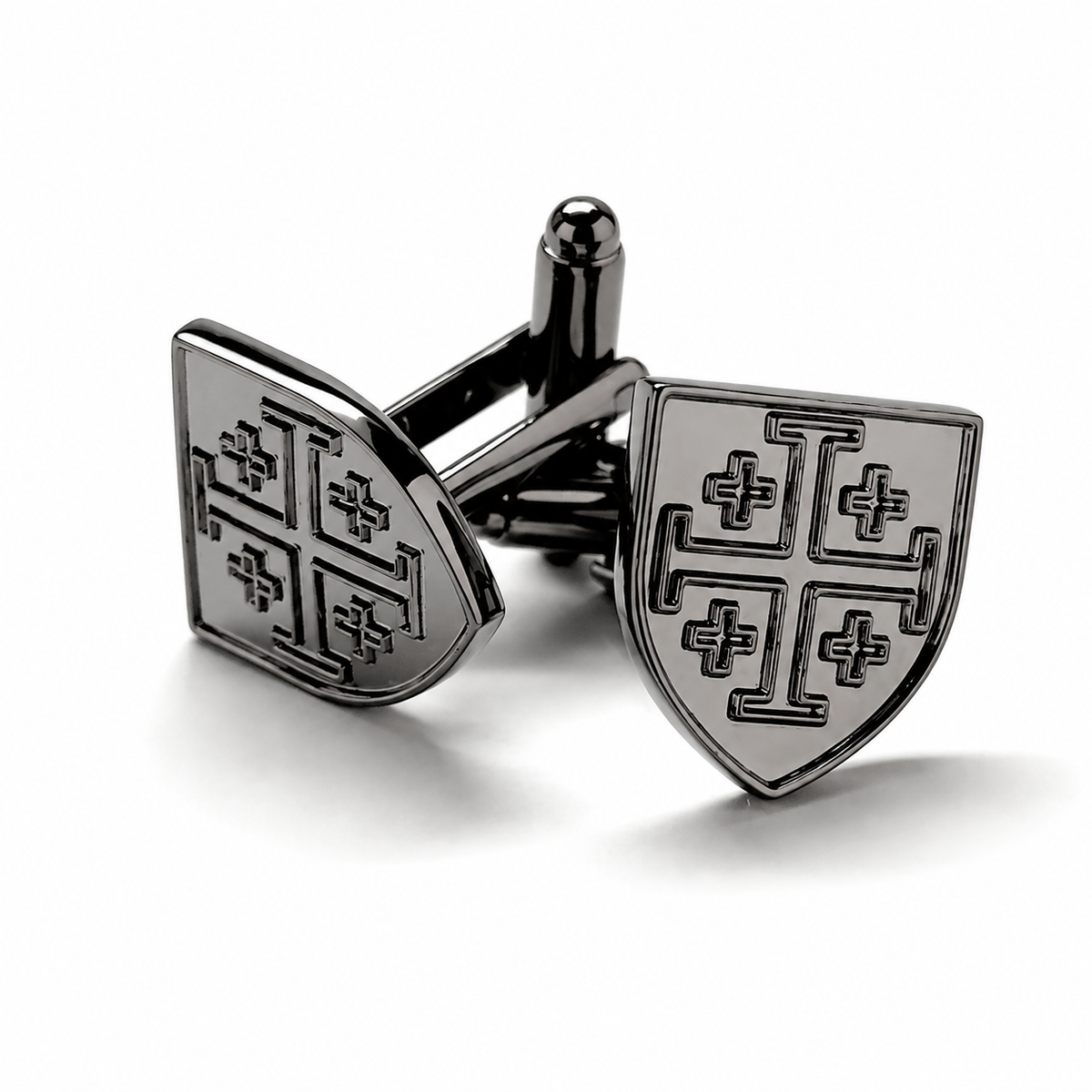 A pair of black metal cufflinks shaped like medieval shields with engraved cross motifs, displayed on a clean white background. Gunmetal Jerusalem Cross shield cufflinks for men