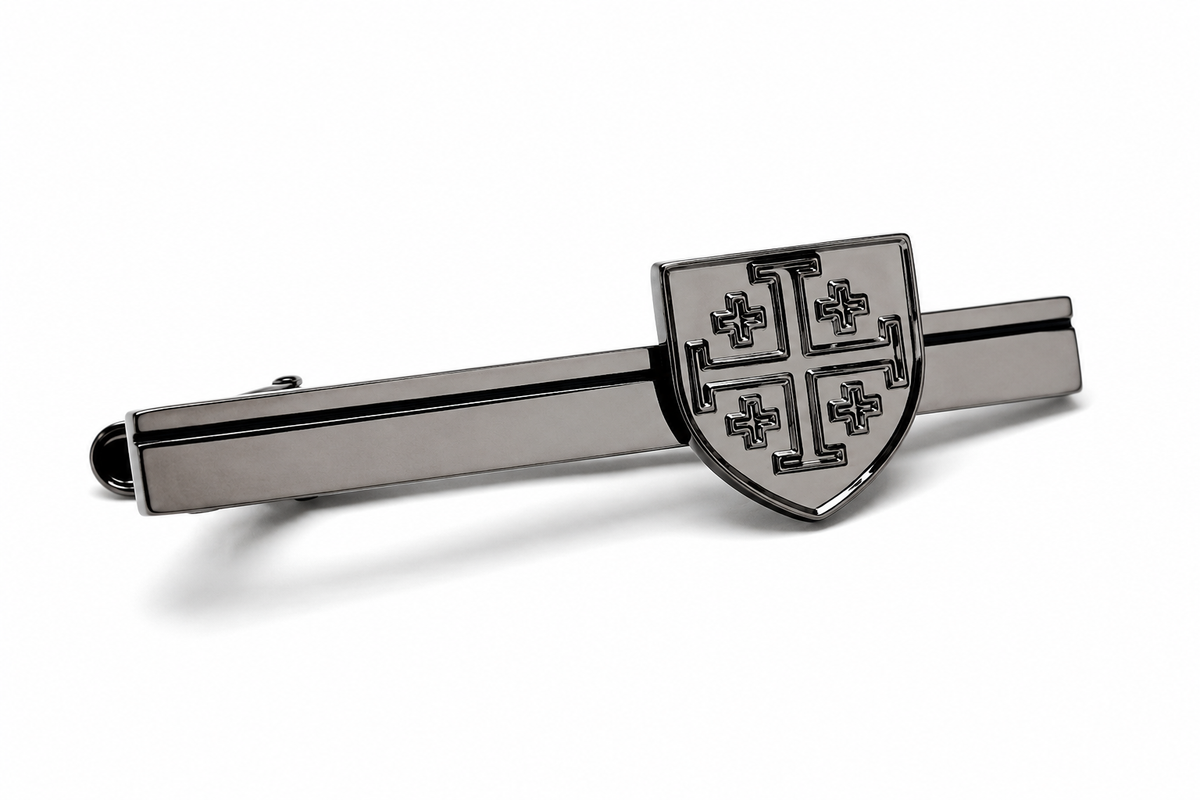 A polished silver-tone metal tie clip featuring a shield crest with four cross motifs, displayed on a clean white background.
