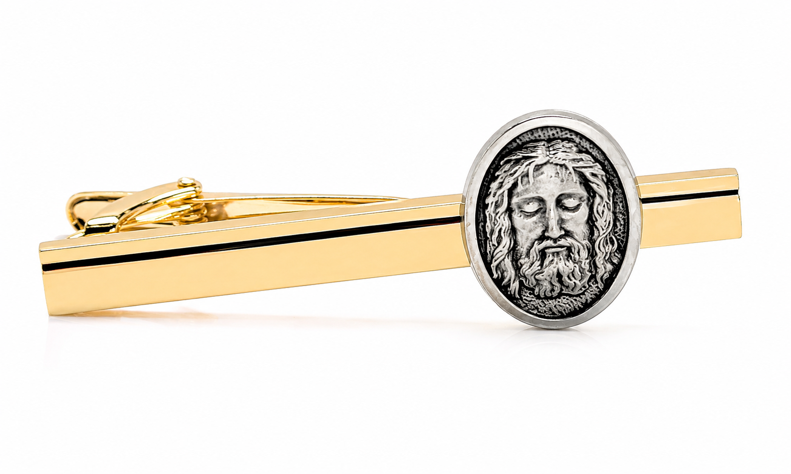 A gold tie bar with a silver oval medallion featuring a detailed portrait of Jesus Christ, shown on a clean white background.