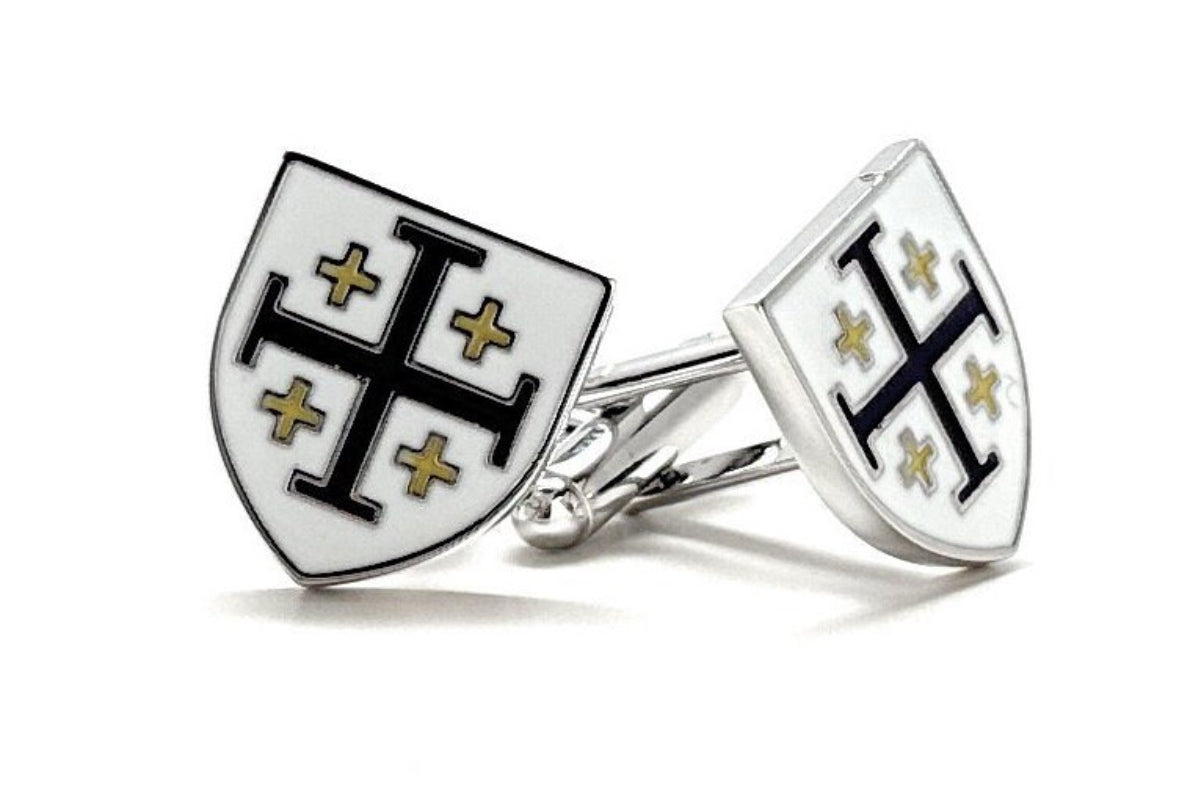 Shield-shaped cufflinks with a cross design on a white background