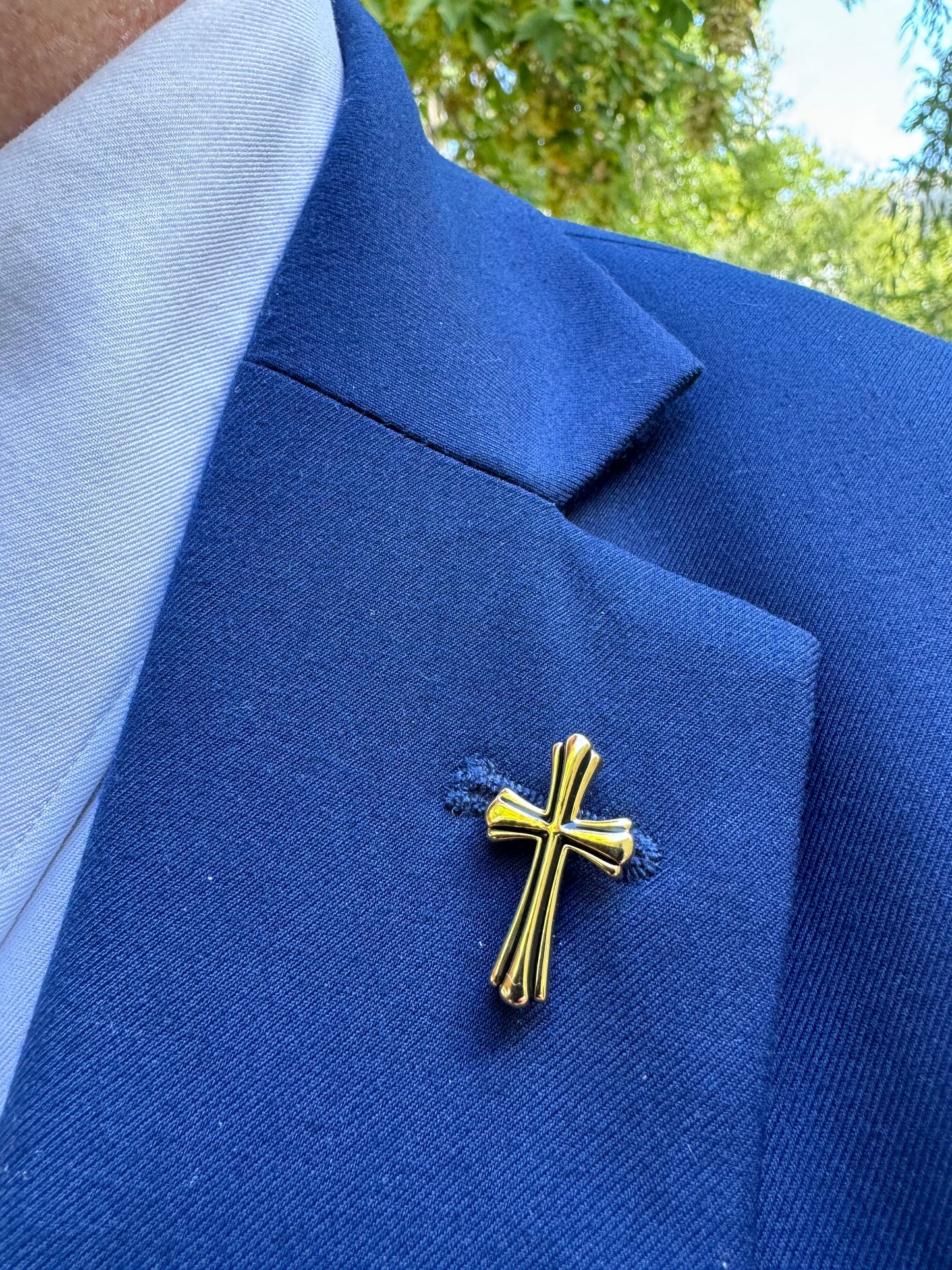 christian gold cross pin on suit lapel
