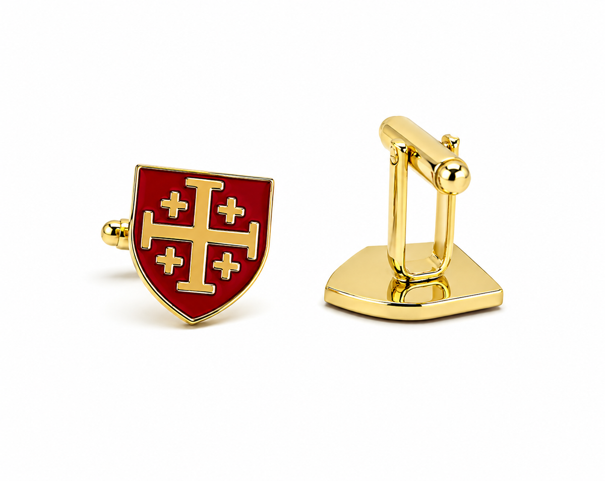 A pair of gold cufflinks on a white background, one showing the front with a red enamel shield design featuring a gold cross, and the other showing the gold clasp mechanism.
