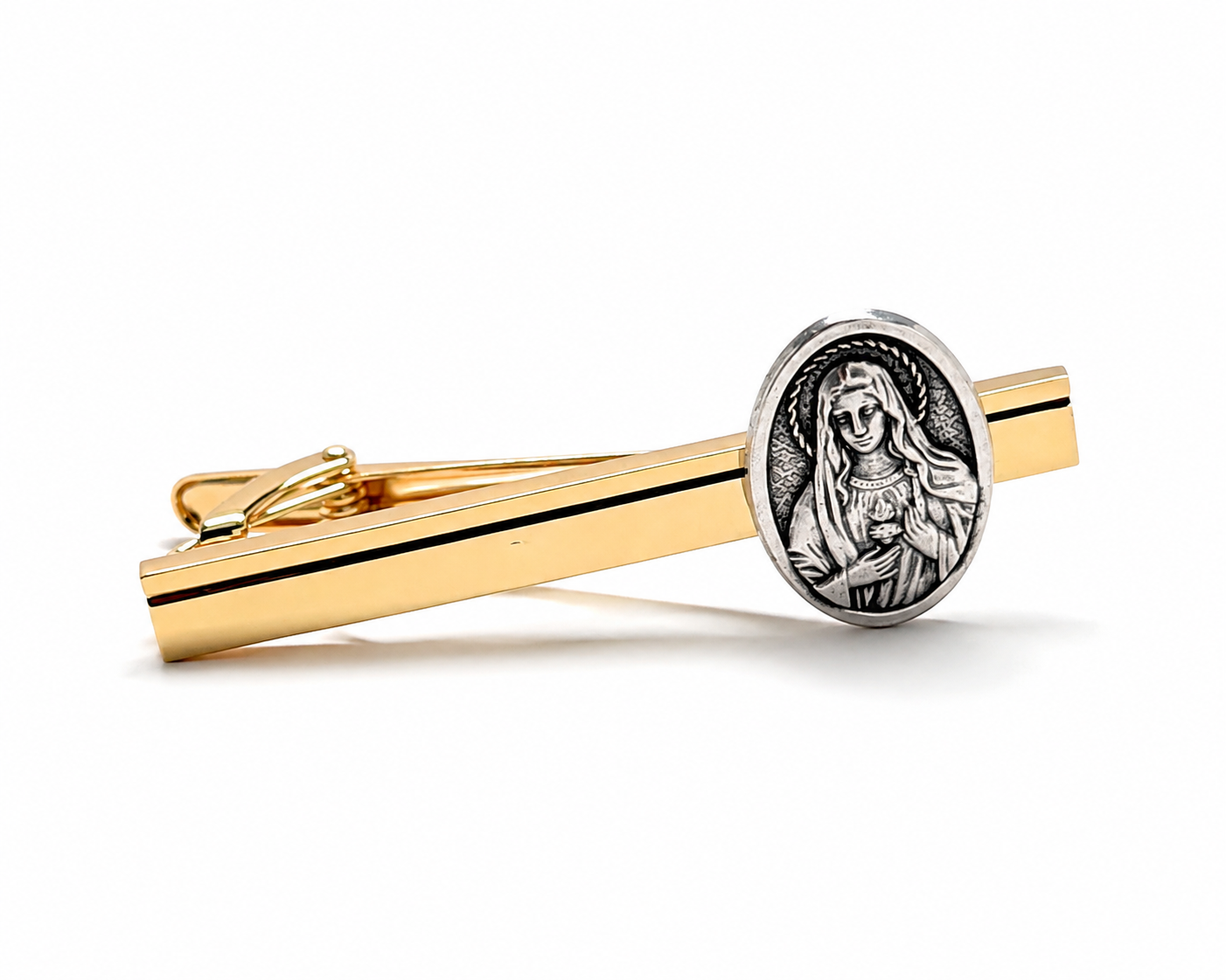 A gold-toned tie bar featuring a silver-toned oval medallion with an embossed religious figure, shown on a clean white background.