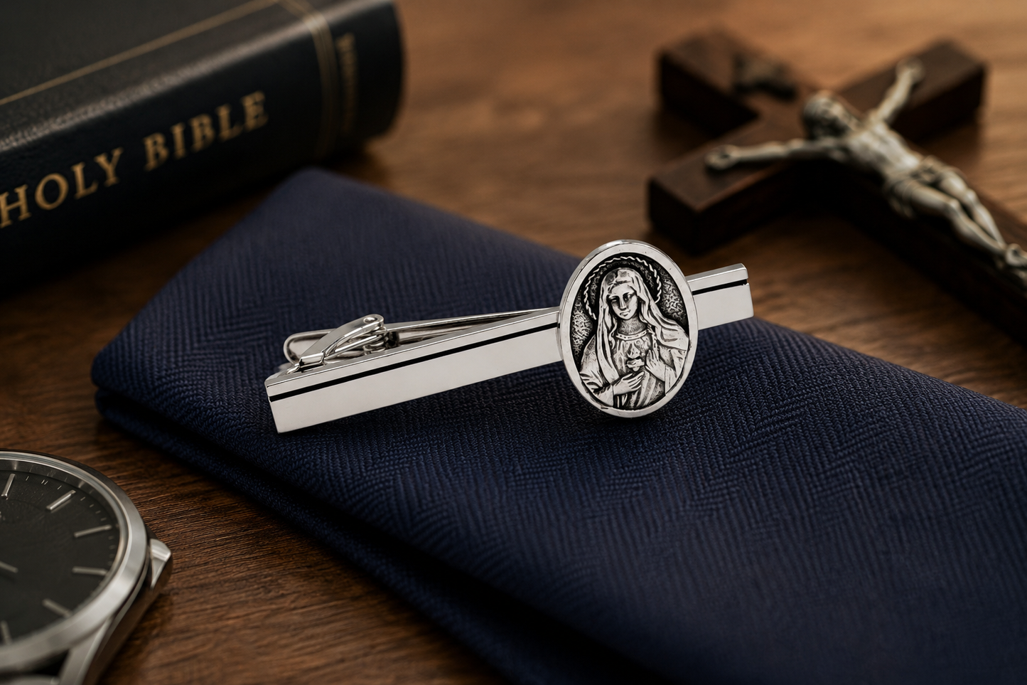 Silver tie clip with religious design on a blue pocket square, with a Bible and cross in the background. Silver religious tie clip with black accent line for formal wear