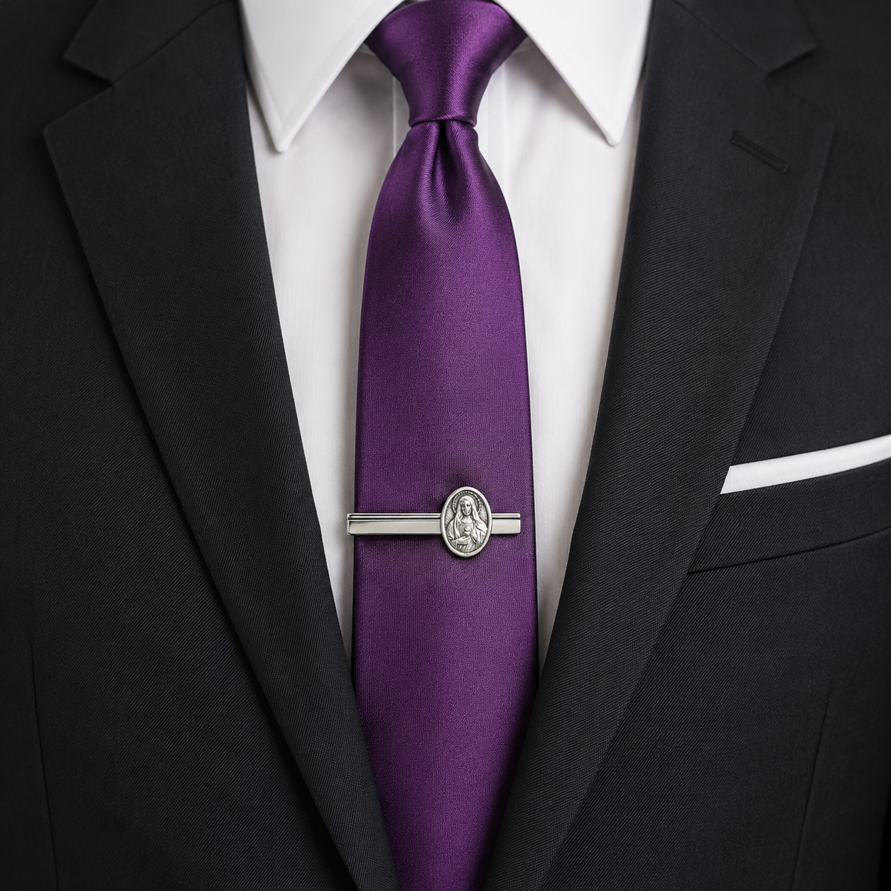 Purple tie with a silver tie clip on a black suit jacket. Elegant Catholic tie bar accessory for weddings church and business attire