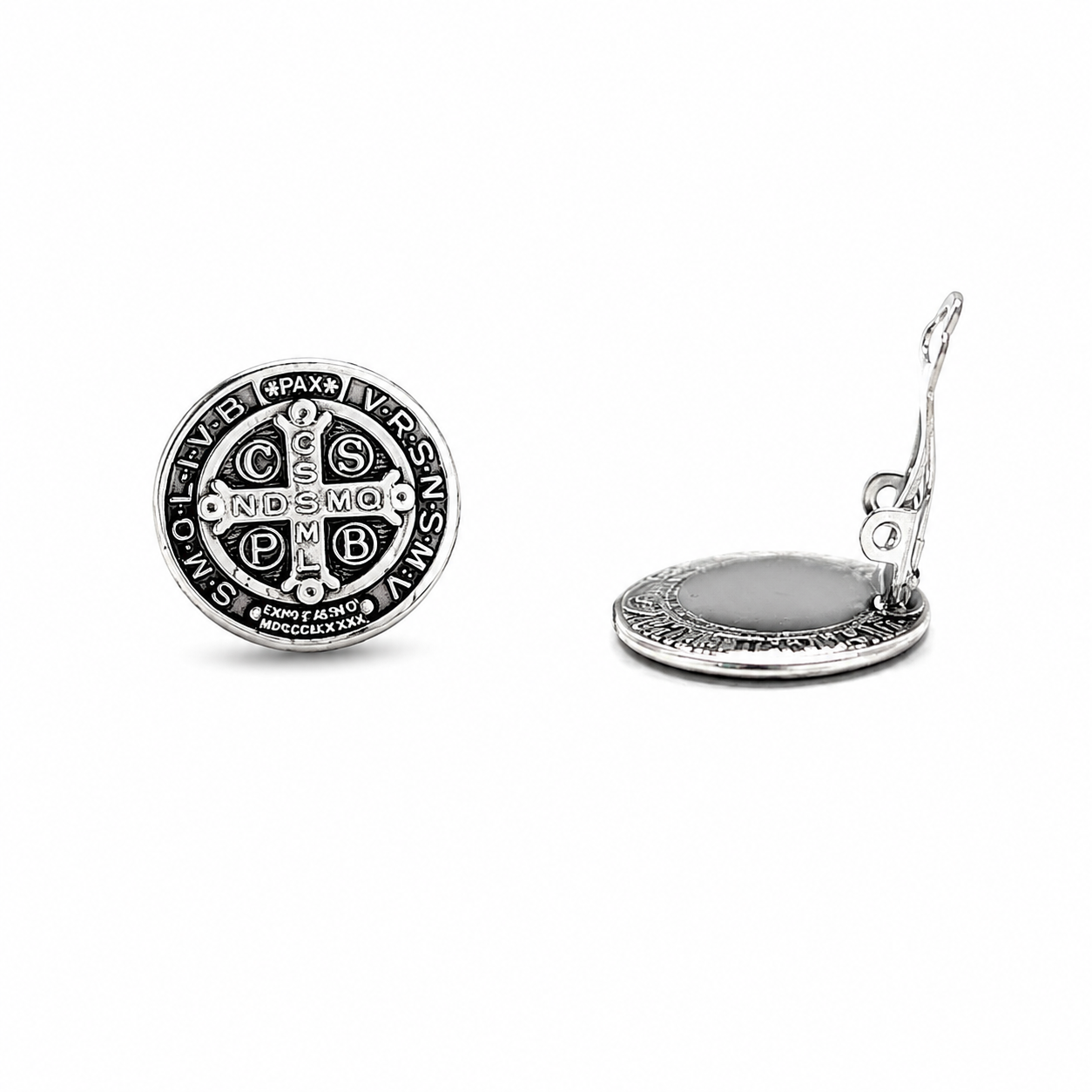 Close-up of silver Saint Benedict clip-on earrings showing the intricate Catholic medal engraving.