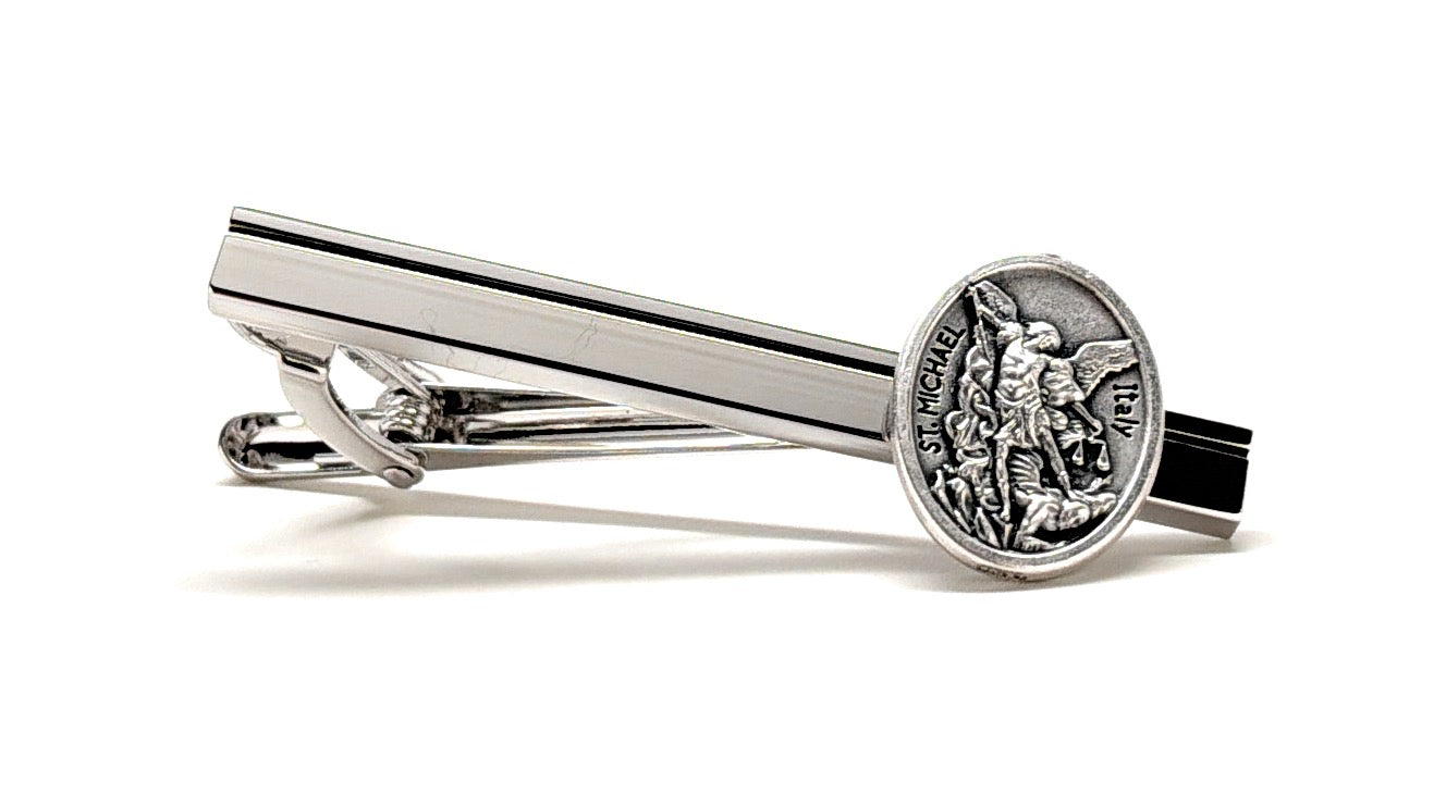 Silver tie clip with a detailed emblem of St Michael on a white background