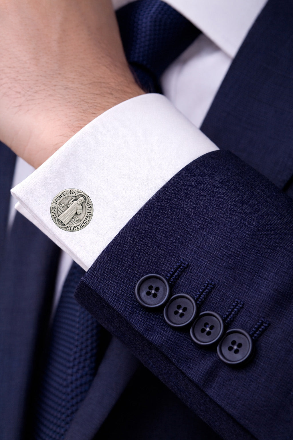 Close-up of a navy suit with white cuff and silver cufflink
