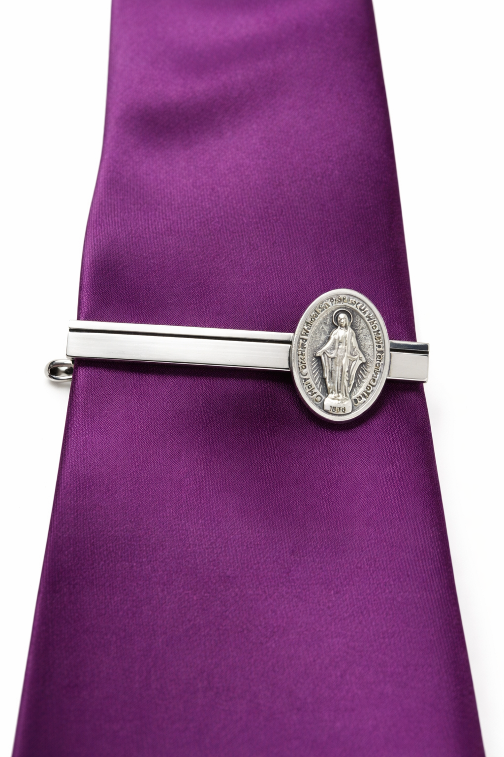Silver tie clip with religious design on a purple tie
