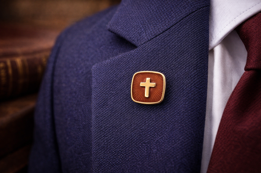 Navy blazer with a gold cross pin on a wooden surface