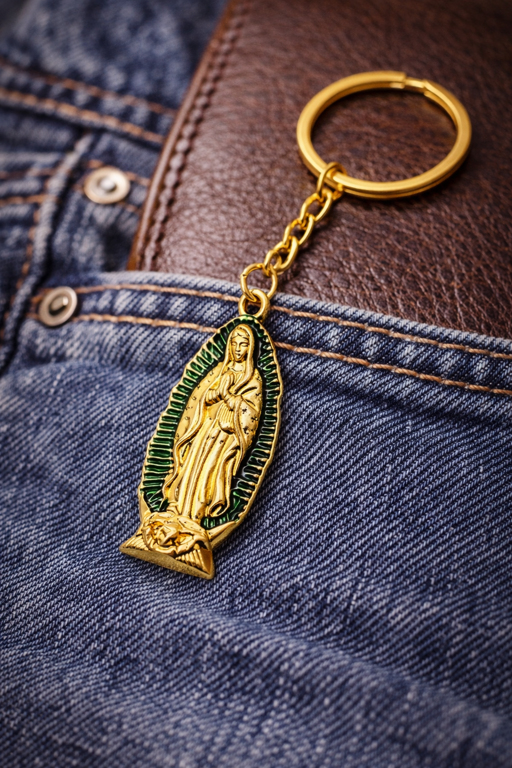 Gold keychain with religious pendant on denim fabric